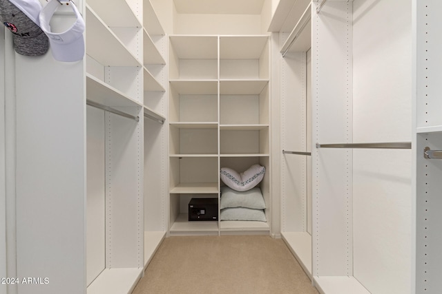 walk in closet featuring light colored carpet