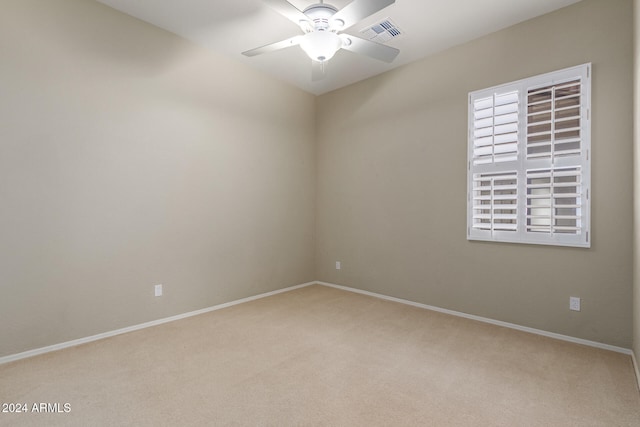 carpeted spare room featuring ceiling fan