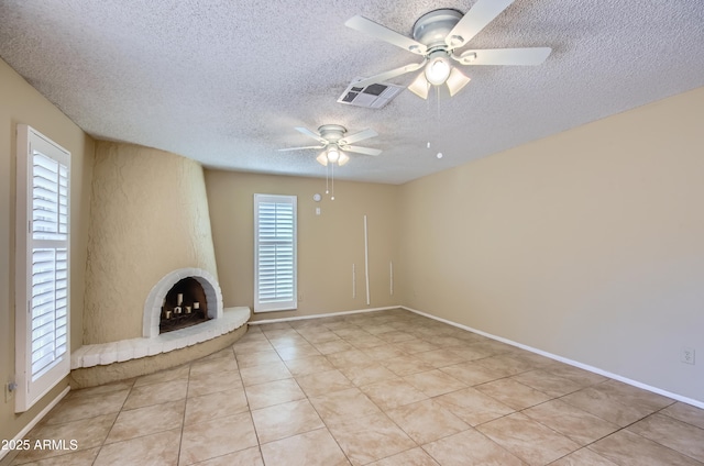 unfurnished living room with light tile patterned flooring, a large fireplace, and a healthy amount of sunlight