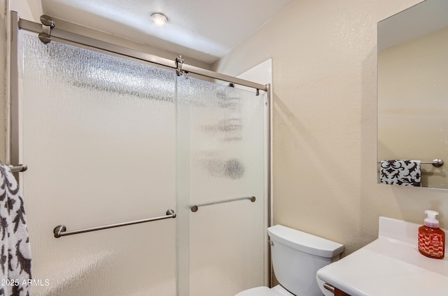 bathroom with toilet, an enclosed shower, and vanity