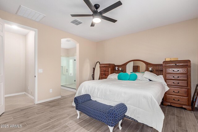 1410 W Popcorn Tree Ave, Queen Creek, AZ 85140 - bedroom with arched walkways, light wood-type flooring, baseboards, a ceiling fan, and connected bathroom