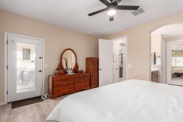 1410 W Popcorn Tree Ave, Queen Creek, AZ 85140 - bedroom with arched walkways, light wood-style flooring, connected bathroom, and a ceiling fan