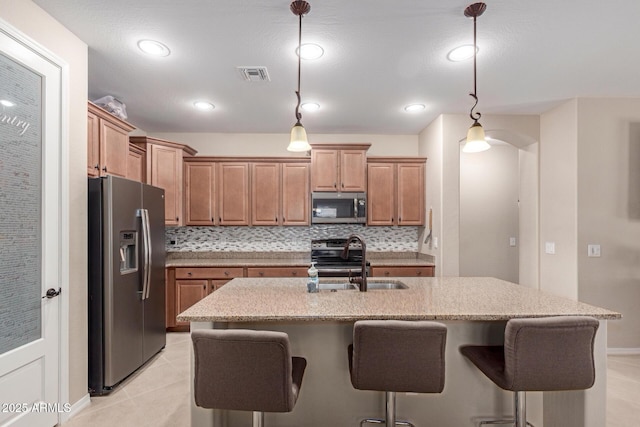 1410 W Popcorn Tree Ave, Queen Creek, AZ 85140 - kitchen with appliances with stainless steel finishes, a sink, a kitchen bar, light stone countertops, and recessed lighting