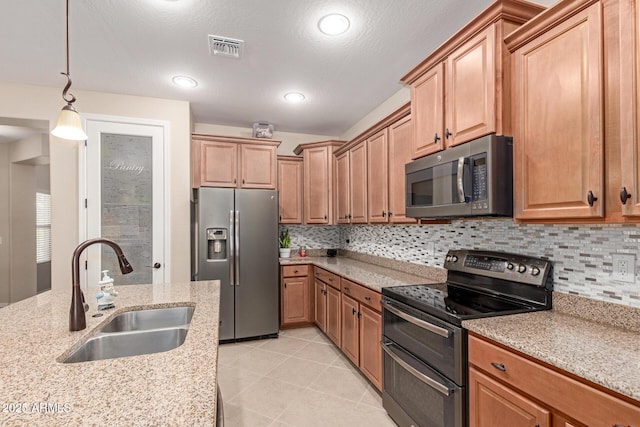 1410 W Popcorn Tree Ave, Queen Creek, AZ 85140 - kitchen featuring appliances with stainless steel finishes, a sink, tasteful backsplash, hanging light fixtures, and light stone countertops