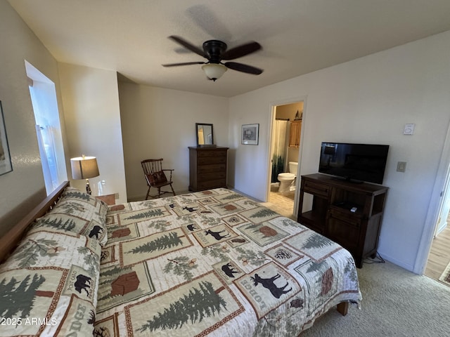 carpeted bedroom with connected bathroom and a ceiling fan