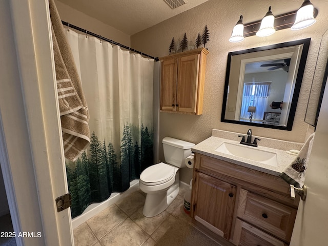 full bath featuring a textured wall, a shower with shower curtain, vanity, and toilet