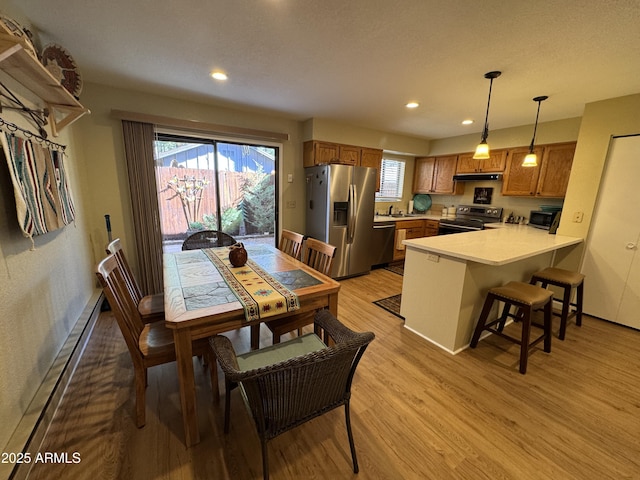 dining area featuring recessed lighting, baseboards, light wood-style flooring, and baseboard heating