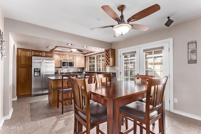 tiled dining space featuring french doors and ceiling fan