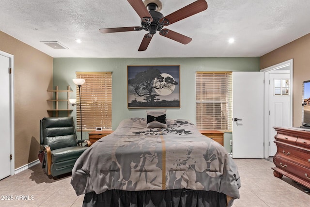 bedroom featuring light tile patterned floors, a textured ceiling, and ceiling fan