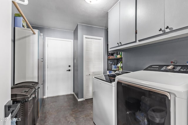 clothes washing area with cabinets and independent washer and dryer