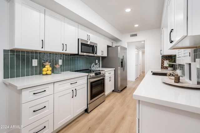 kitchen featuring backsplash, stainless steel appliances, sink, light hardwood / wood-style floors, and white cabinetry