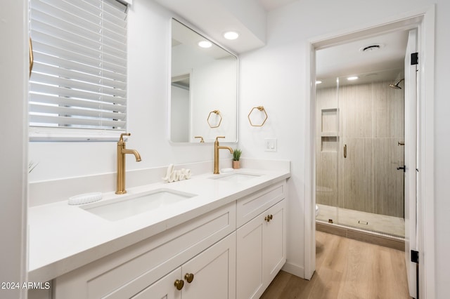 bathroom featuring wood-type flooring, vanity, and a shower with door