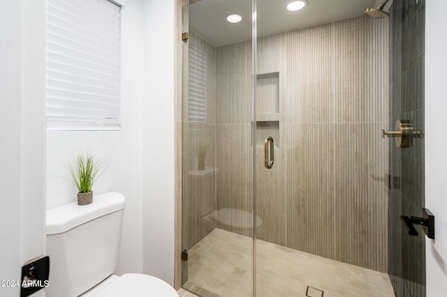 bathroom with an enclosed shower and toilet