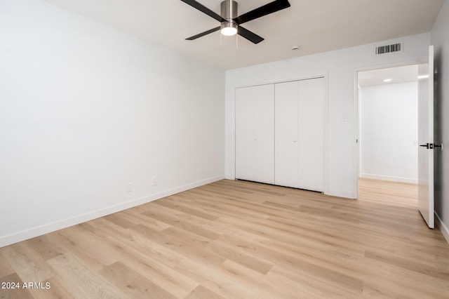 unfurnished bedroom with a closet, light hardwood / wood-style flooring, and ceiling fan