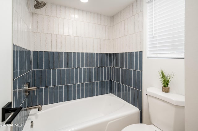 bathroom with tiled shower / bath combo and toilet