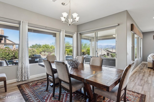 dining area featuring hardwood / wood-style floors, a mountain view, and an inviting chandelier