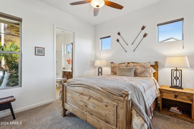 carpeted bedroom featuring connected bathroom, ceiling fan, and multiple windows