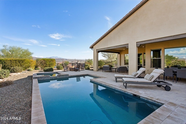 view of swimming pool featuring an in ground hot tub, a mountain view, and a patio