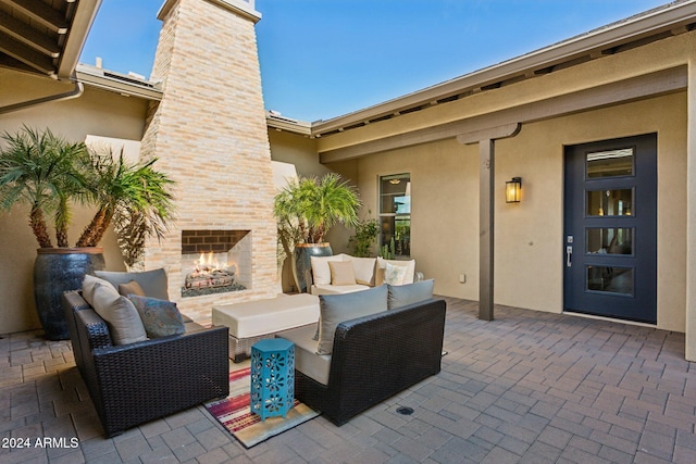 view of patio with an outdoor living space with a fireplace