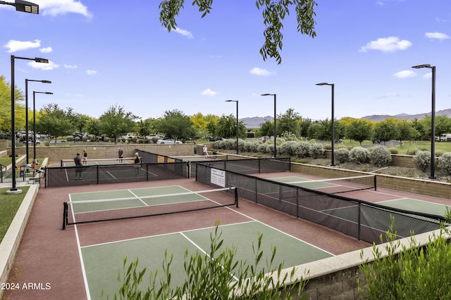 view of sport court with a mountain view and basketball hoop