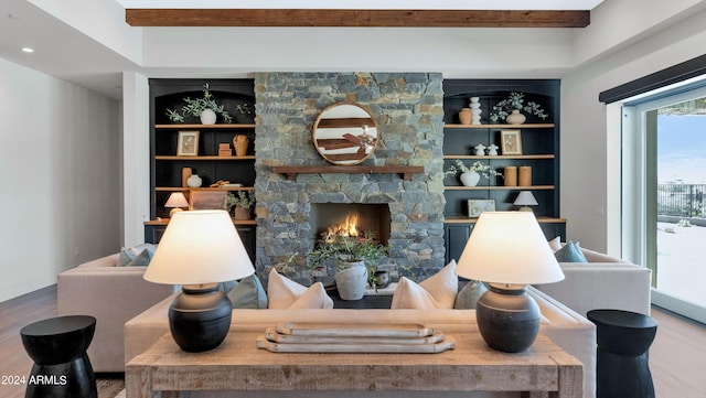 living room with a fireplace, hardwood / wood-style floors, built in shelves, and beam ceiling