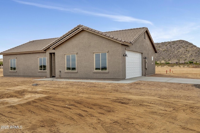 rear view of house featuring a garage and a mountain view