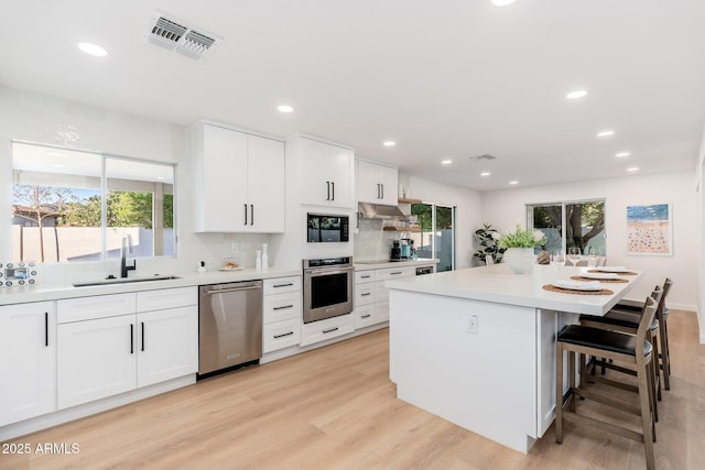 7223 N 14th St, Phoenix, AZ 85020 - kitchen featuring stainless steel appliances, a sink, healthy amount of natural light, light wood finished floors, and recessed lighting