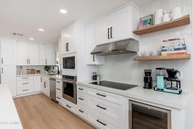 7223 N 14th St, Phoenix, AZ 85020 - kitchen featuring black appliances, under cabinet range hood, beverage cooler, a sink, and backsplash