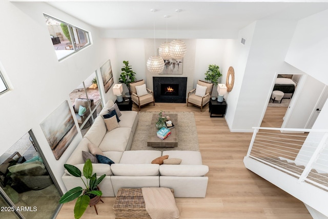 7223 N 14th St, Phoenix, AZ 85020 - living area featuring light wood-style floors, a warm lit fireplace, a chandelier, and baseboards