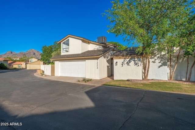 7223 N 14th St, Phoenix, AZ 85020 - view of front facade featuring driveway, central air condition unit, a mountain view, and an attached garage