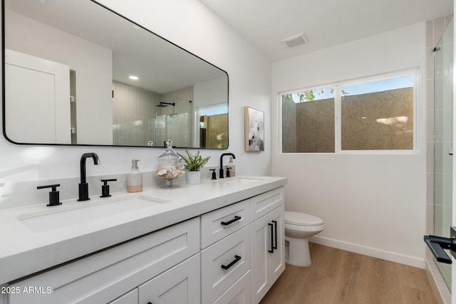 7223 N 14th St, Phoenix, AZ 85020 - full bathroom with tiled shower, wood finished floors, double vanity, toilet, and baseboards