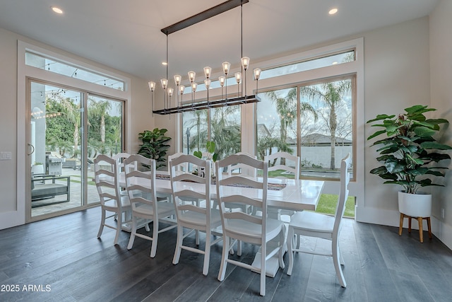 dining area with plenty of natural light, dark hardwood / wood-style floors, and a chandelier