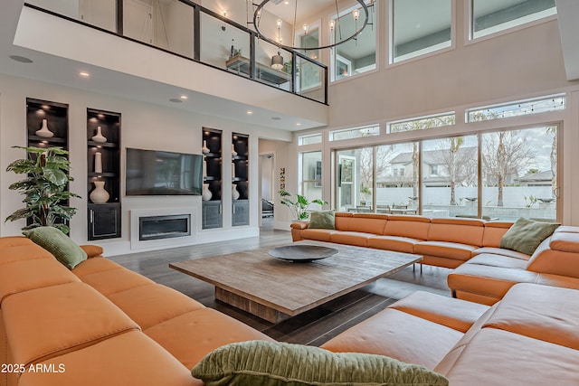 living room with hardwood / wood-style flooring, built in shelves, and a wealth of natural light