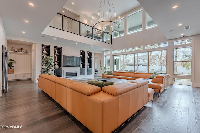 living room featuring a high ceiling, dark hardwood / wood-style floors, and a chandelier