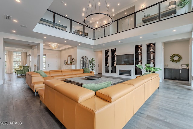 living room with a high ceiling, wood-type flooring, and a chandelier