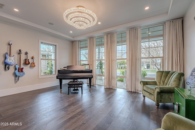 sitting room featuring a notable chandelier, a tray ceiling, and dark hardwood / wood-style floors