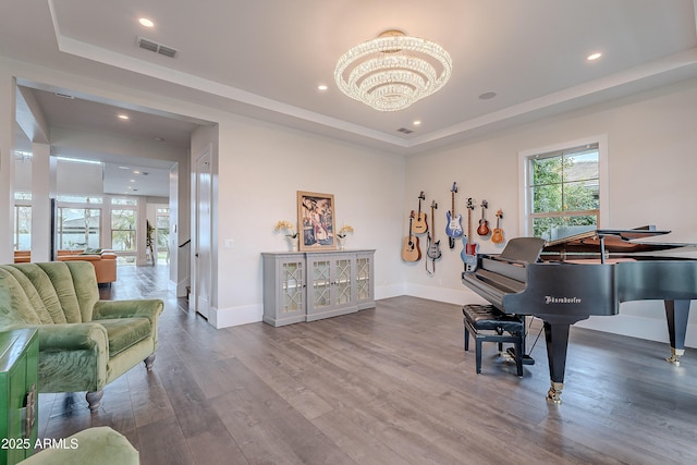 misc room featuring hardwood / wood-style flooring, a tray ceiling, and an inviting chandelier