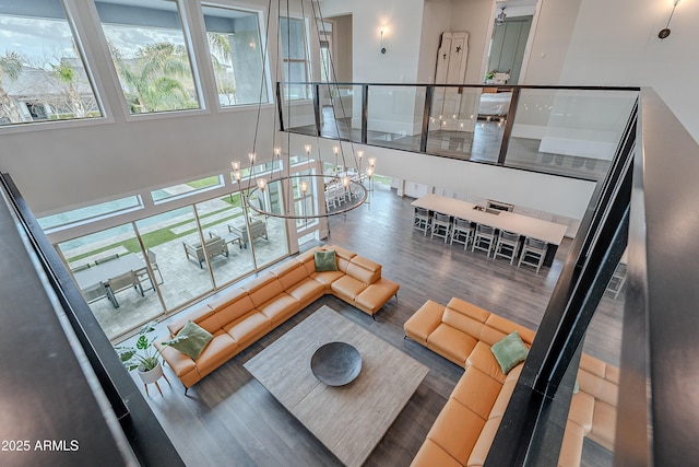 living room with hardwood / wood-style flooring, a healthy amount of sunlight, and a chandelier