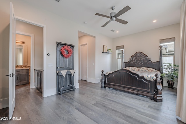 bedroom featuring multiple windows, ceiling fan, and light wood-type flooring