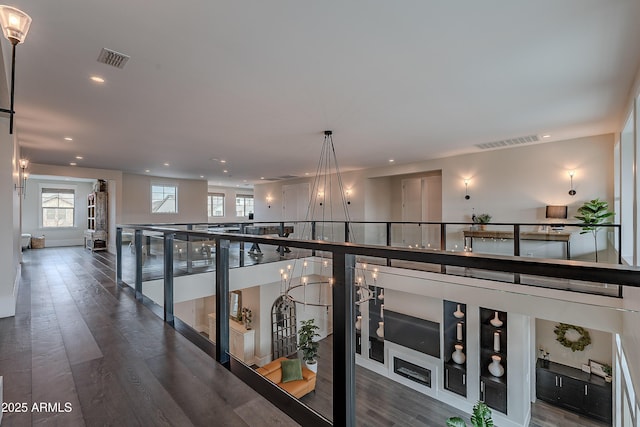 hallway featuring a notable chandelier and dark hardwood / wood-style flooring