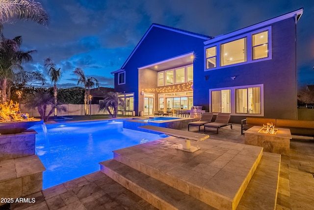 view of pool featuring a fire pit, a patio area, pool water feature, and an in ground hot tub