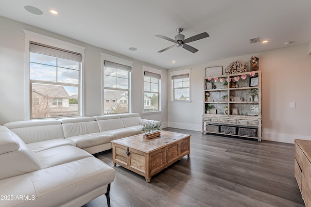 living room with dark wood-type flooring and ceiling fan