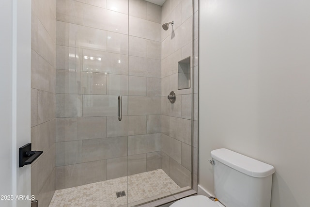 bathroom with toilet and a shower with shower door