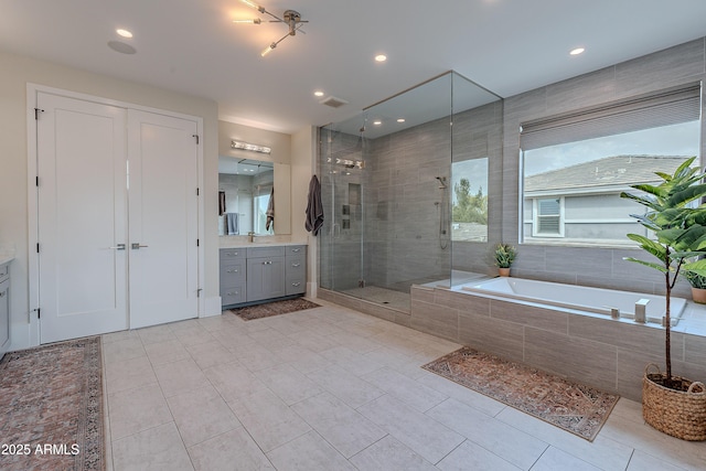 bathroom with tile patterned flooring, plus walk in shower, plenty of natural light, and vanity