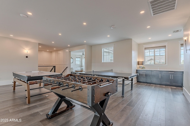 rec room featuring light hardwood / wood-style flooring and ceiling fan