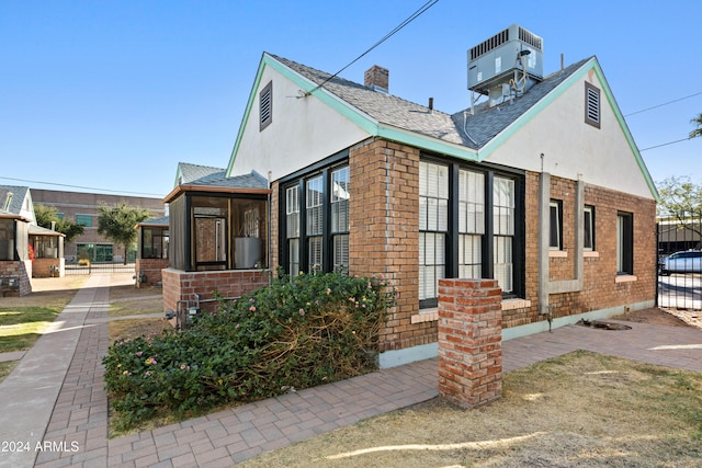 view of side of property featuring central air condition unit and a sunroom