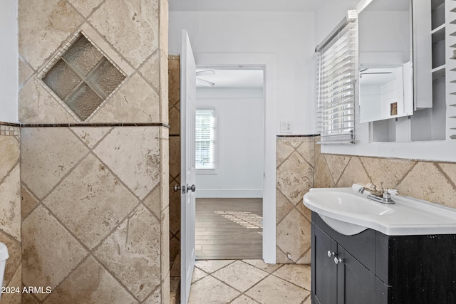 bathroom with vanity, wood-type flooring, and tile walls