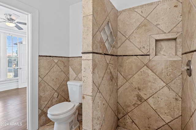 bathroom with ceiling fan, toilet, wood-type flooring, and tile walls