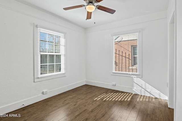 empty room with dark hardwood / wood-style floors and ceiling fan