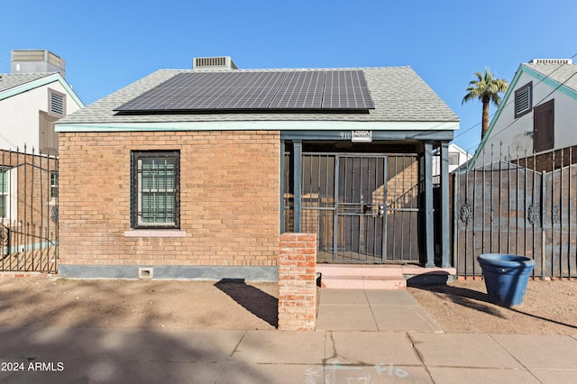 back of house featuring solar panels